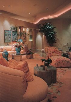 a living room filled with lots of couches and chairs in front of a plant