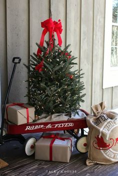 a small christmas tree sitting on top of a wooden cart