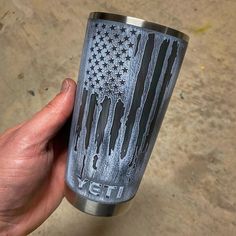 a hand holding a yeti cup with an american flag painted on it