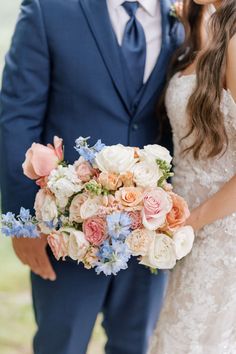 a bride and groom pose for a wedding photo with flowers in their bouquet at the end of their ceremony