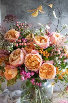 a vase filled with lots of flowers on top of a table