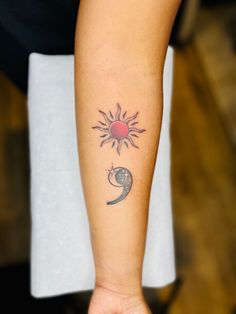 a woman's arm with a tattoo on it that has the sun and moon