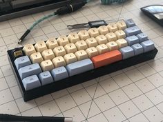 a computer keyboard sitting on top of a table next to a calculator and pen