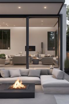 Modern outdoor patio with a fire pit and large glass doors leading into a spacious, elegantly furnished living room. Simple Diy Projects