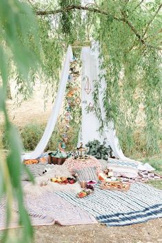 an outdoor picnic is set up under a tree