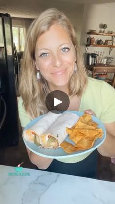 a woman holding a plate with food on it