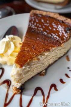 a piece of cheesecake on a white plate with caramel sauce and whipped cream