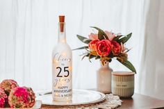 a bottle of wine sitting on top of a table next to flowers and other decorations