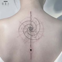 the back of a woman's neck with an abstract tattoo