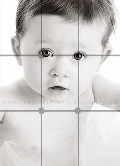 a black and white photo of a baby looking at the camera with an intense look on his face