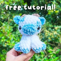 a hand holding a small blue and white stuffed animal with the words free pattern on it