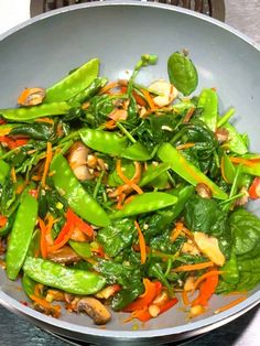 a pan filled with green vegetables on top of a stove