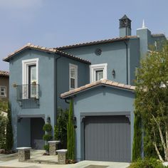 a blue house with two garages and a clock tower