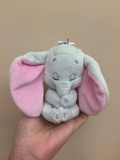 a small stuffed elephant sitting on top of a person's hand