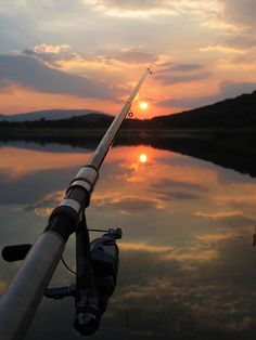 the sun is setting behind a fishing rod