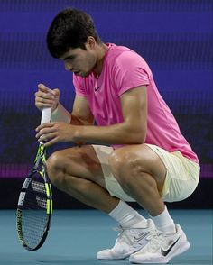 a man kneeling down holding a tennis racquet