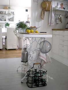 a kitchen with white cabinets and an island in the middle filled with utensils