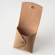 a brown leather case with a button on the front and side is folded in half