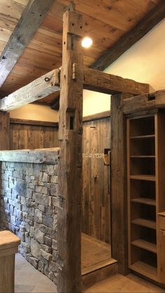 an unfinished bathroom with stone walls and exposed beams, along with built - in shelving