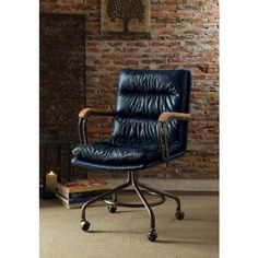 a black office chair sitting in front of a brick wall with a book on the floor