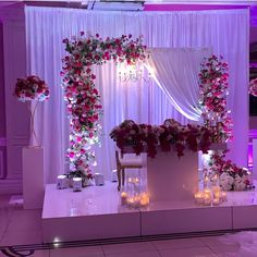 a decorated stage with candles and flowers on the side for a wedding or event reception