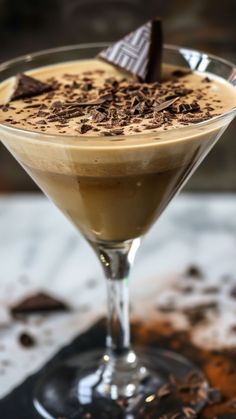 a glass filled with liquid and topped with chocolate