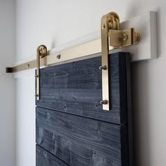 a close up of a wooden door with brass hardware on the handlebars in a room