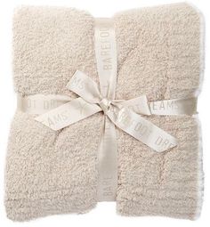 two towels wrapped in white with ribbon and sayings on the side, tied together