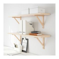 two shelves on the wall with books and binders next to each other in front of a computer desk