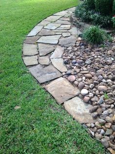 a stone path in the middle of some grass