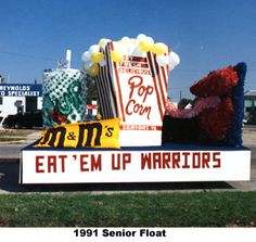 a sign that says eat'em up warriors and popcorn on the side of the road