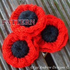 three crocheted red flowers with black centers