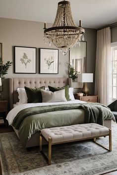 a bedroom with a large bed, chandelier and two pictures on the wall