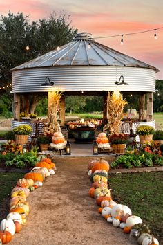 a gazebo filled with lots of pumpkins and gourds on the ground