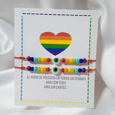 two bracelets with beads and a heart on the front one has a rainbow bead