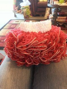 a red and white bowl sitting on top of a couch