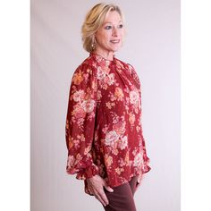 Staccato Ruffle Neck Blouse with Long Sleeves is a beauty with its deep colors of fall! Here’s What We Love About This Item: Beautiful long sleeve top with ruffled neck and sleeves Rust and cream with brushes of purple and rose gold flecks Bodice is fully lined, sleeves are sheer with gathered shoulder seam High-low hem 100% Polyester Imported Our Styling Tips: Dress up this rust colored (Marsala) floral top by pairing with wide leg pants or suede slacks for the Holidays. Go casual with jeans (p Fall Workwear Blouse With Ruffle Hem, Fall Long Sleeve Top With Bishop Sleeves, Red Lantern Sleeve Top For Fall, Floral Print Tops For Fall, Red Lantern Sleeve Blouse For Fall, Fall Long Sleeve Blouse With Ruffles, Fall Blouse With Ruffle Hem And Ruffled Collar, Fall Floral Print Blouse With Ruffled Collar, Fall Floral Print Bishop Sleeve Tops