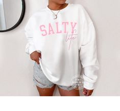 Salty Life Sweatshirt, Beach Sweatshirt, Beach shirt, Swimsuit Coverup, Salty Life shirt, Plus Size Beach Sweatshirts, Gift for Her, Coastal ⭐⭐ PLEASE NOTE:  Model in listing photos is wearing 2-3 sizes 'Larger' than her typical size for an oversized trendy look.  Please order larger if you would like a longer/bigger sweatshirt.  ⭐ This item is MADE TO ORDER just for you!  Our graphic sweatshirts are very soft, very cute and sure to keep you warm in the colder months and cozy on cool Sumer nights.     ------------------------------------------------------    S W E A T S H I R T  - D E T A I L S ------------------------------------------------------- The sweatshirts are UNISEX - they are meant to have a relaxed fit, please refer to the size chart. ♡  Gildan unisex crewneck sweatshirt ♡  Pre Beach Sweatshirt, Plus Size Beach, Beach Sweater, Coverup Beach, Screen Printing Shirts, Trendy Collection, Beach Shirt, Beach Shirts, Sweater Making