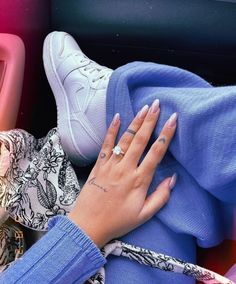 a woman's hand with a diamond ring on her left wrist, sitting in the back seat of a car