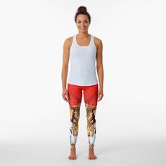 a woman standing in front of a white background wearing red and yellow leggings