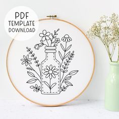 the embroidery pattern shows a vase with flowers in it