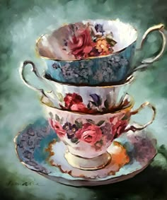 three tea cups and saucers are stacked on top of each other with flowers painted on them