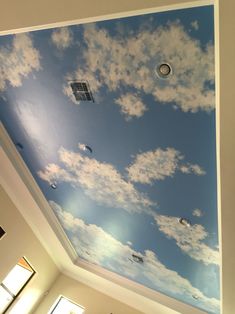 the ceiling is painted with clouds and blue sky