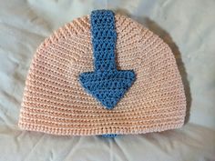 a crocheted hat with a blue arrow on it