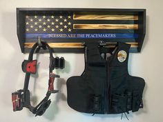 an american flag is hanging on the wall next to a life jacket and harness holder