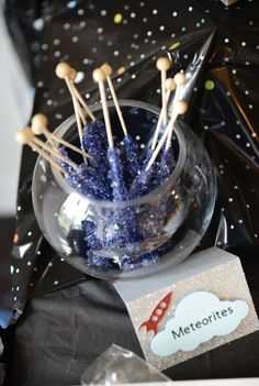 a glass bowl filled with blue and white candy sticks