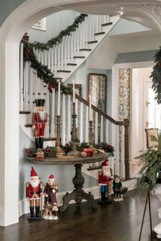 christmas decorations are on the table in this entry way