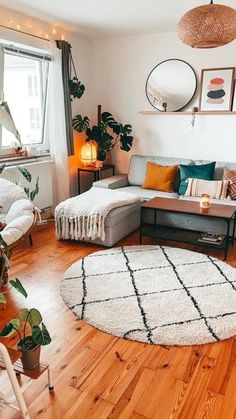 a living room filled with furniture and lots of plants on top of a hard wood floor