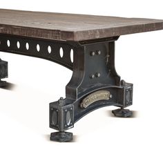 an old wooden table with metal legs and wheels on the bottom, against a white background