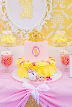 a pink and yellow cake on top of a table